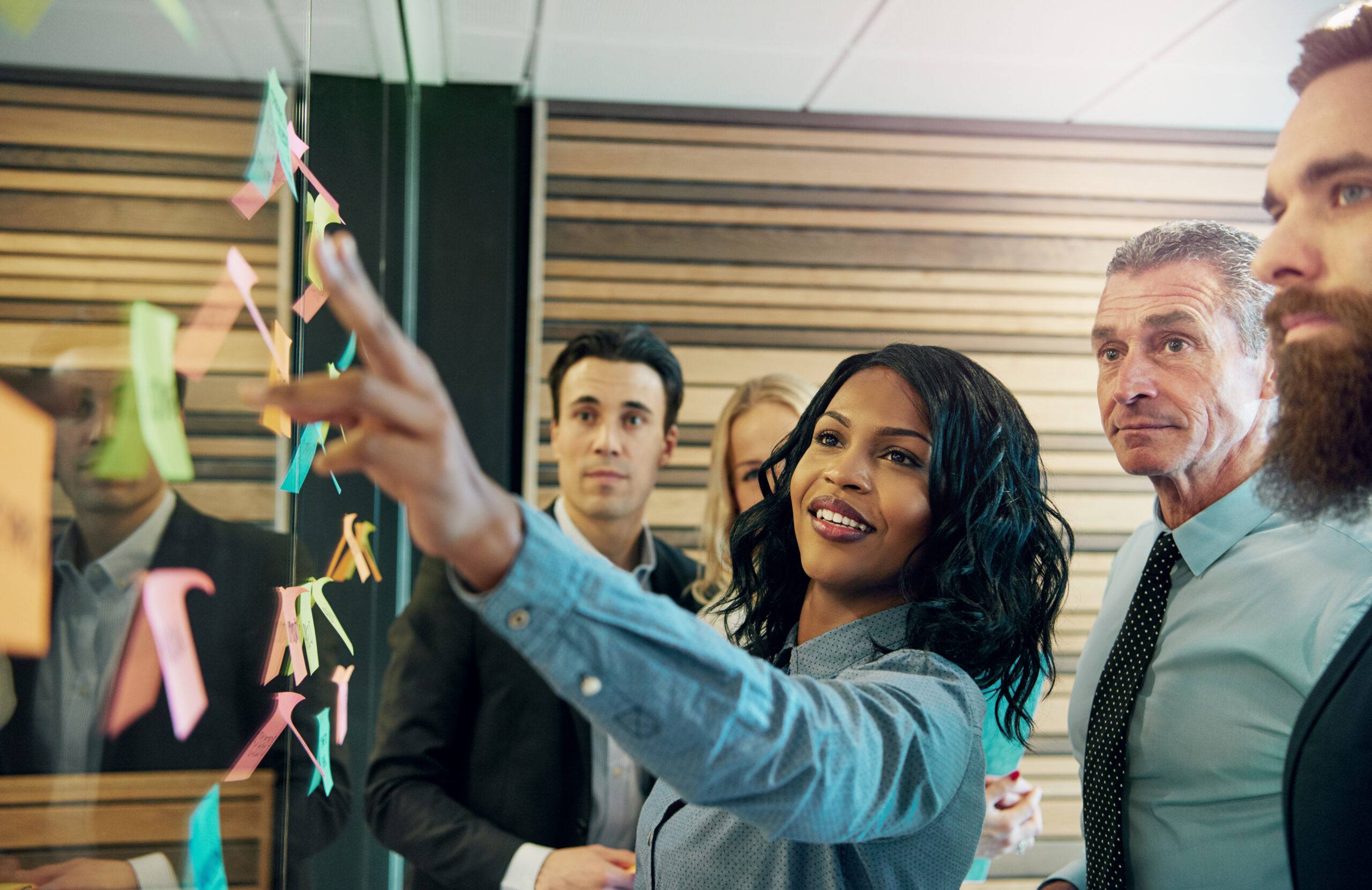 Team brainstorming with sticky notes on a glass wall