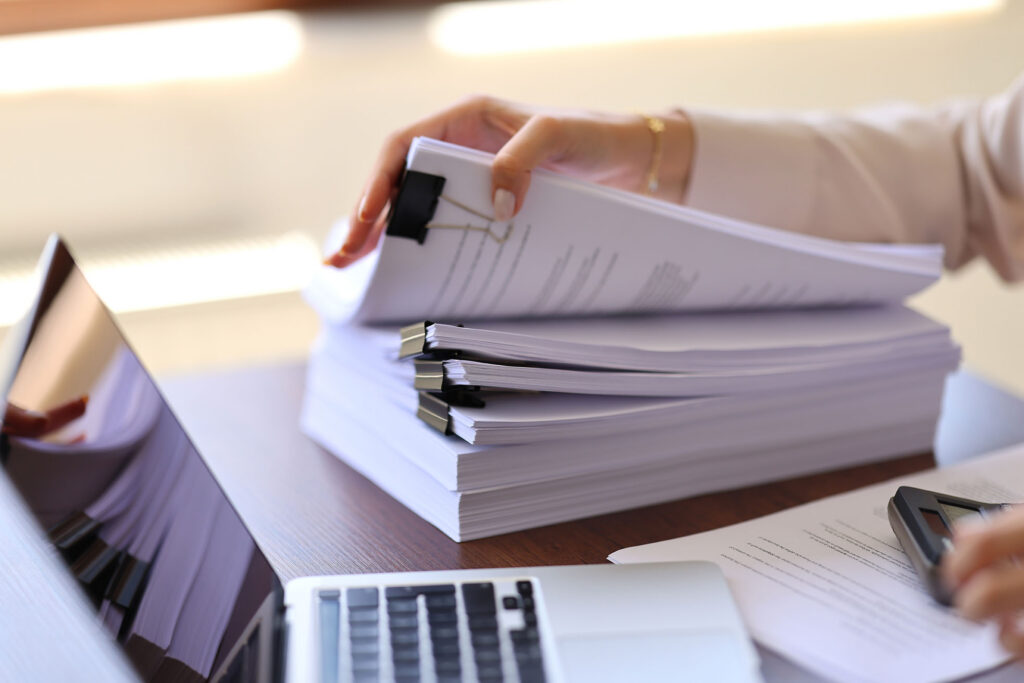 Reviewing stacks of grant application documents and paperwork