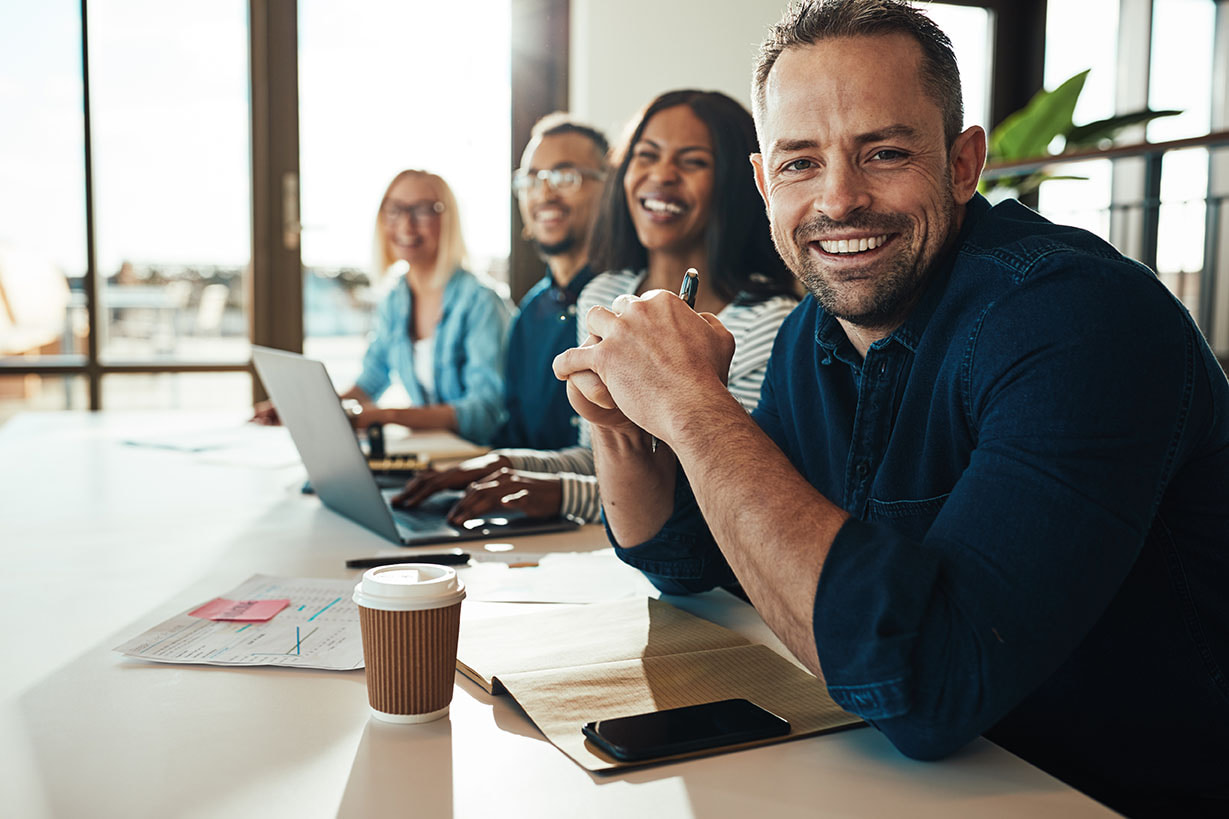 Smiling diverse team working together at a meeting table in a bright office