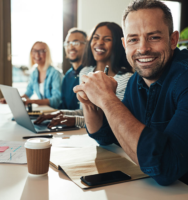 Smiling diverse team working together at a meeting table in a bright office