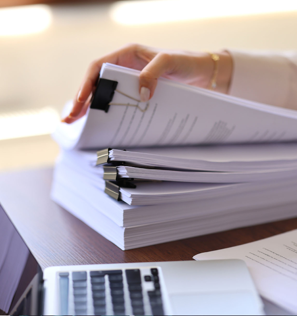 Reviewing stacks of grant application documents and paperwork